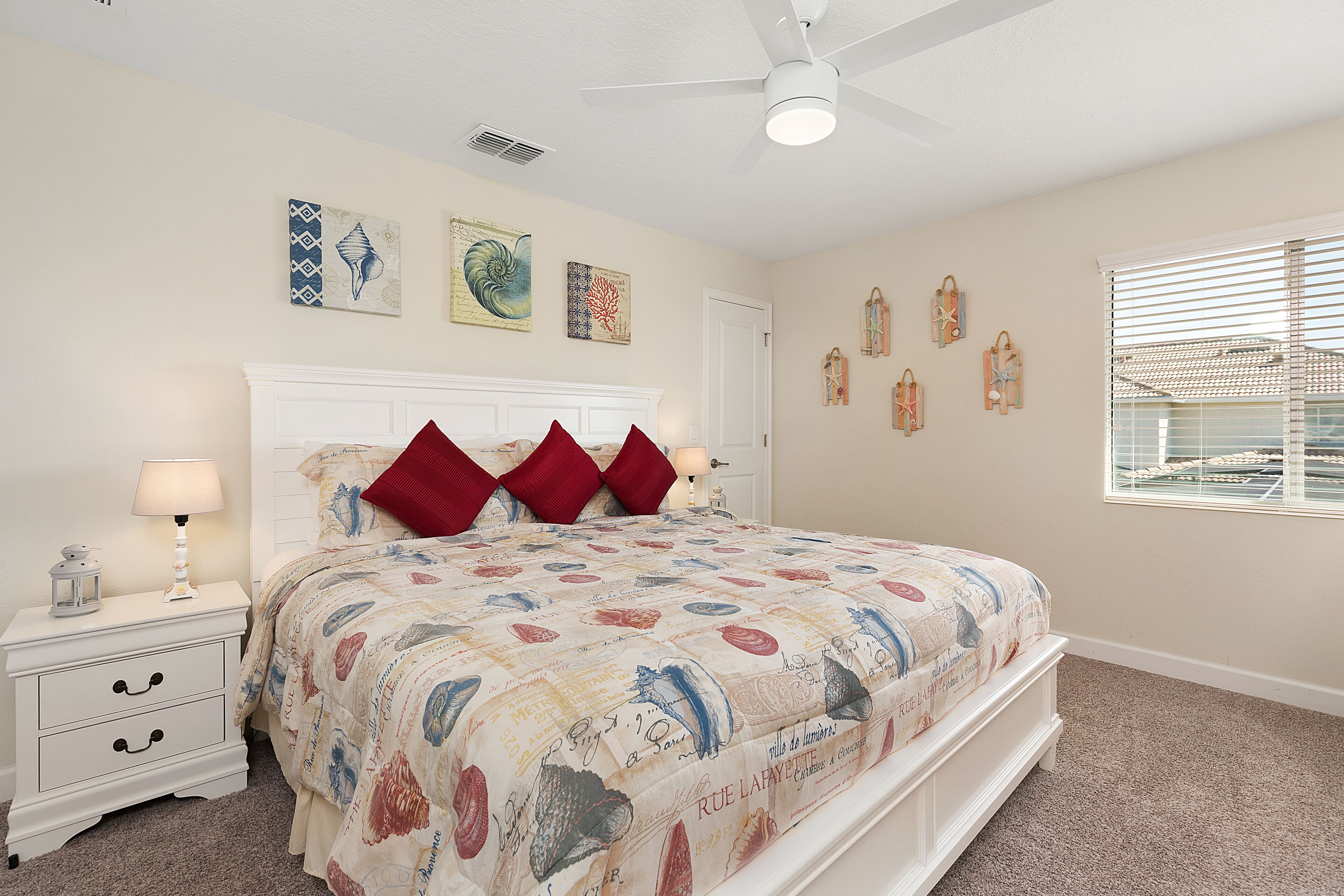 A bedroom with a bed, nightstand, and wall art.