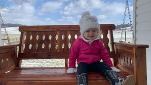 A child sitting on a wooden bench with a snowy landscape in the background. - Twin Maple Cottage, a country cottage get away near Blacksburg - 3BR 1Bath (Dublin)