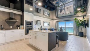 Una cocina moderna con una isla grande, electrodomésticos integrados y un balcón con vistas.