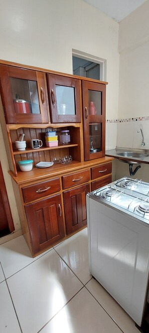 Une cuisine avec des meubles de rangement en bois, une cuisinière et un évier.