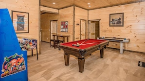 A pool table in a wooden room with a wooden ceiling and walls, a foosball table, and a table tennis table. - Free Tickets | Theater, Game Room, Hot Tub, & Fire Pit, 1.5 Miles to Downtown (Gatlinburg)