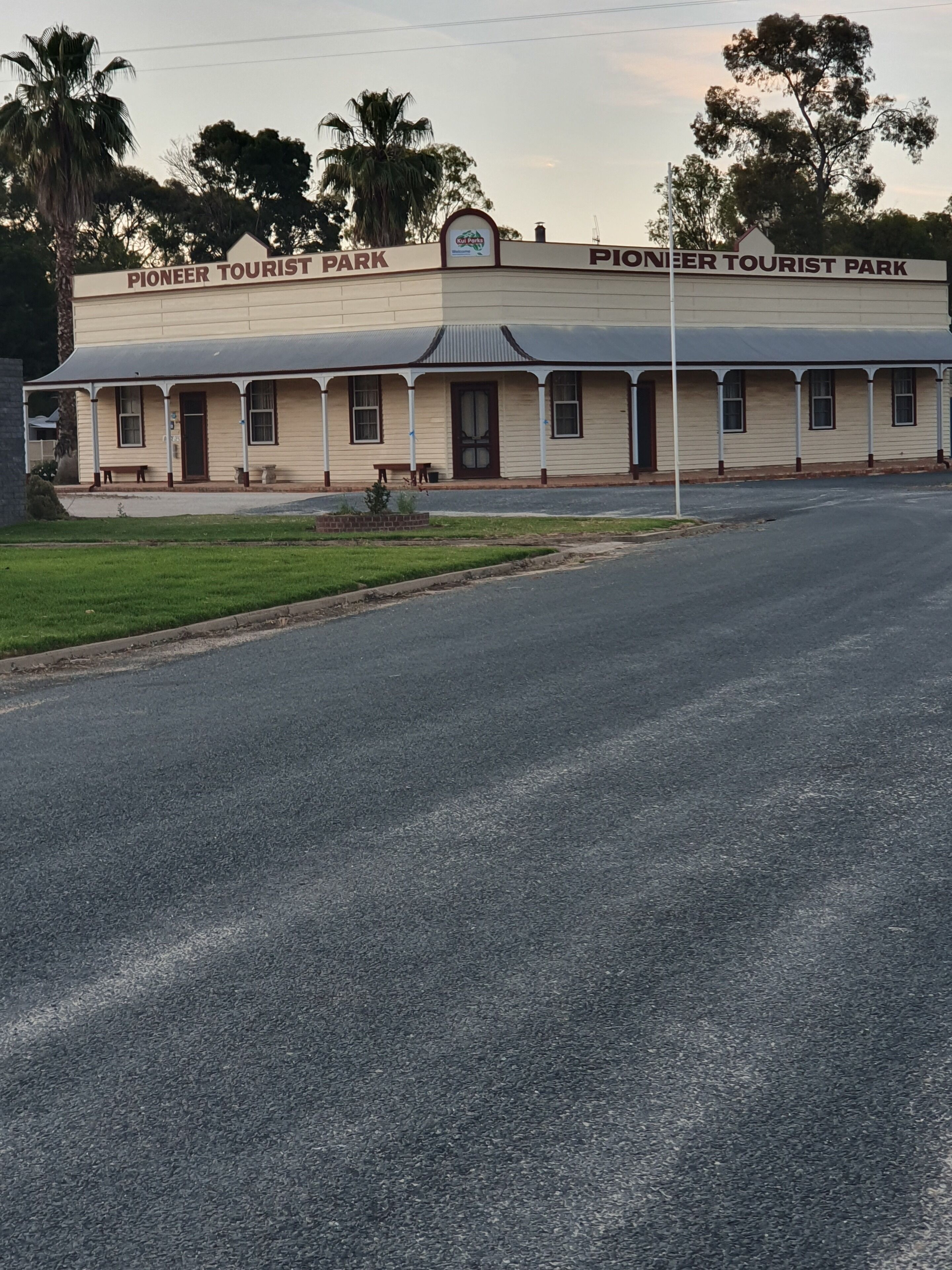 Pioneer Tourist Park, a two-story building with a flat roof and a porch.