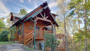 Eine Holzhütte mit Holzwänden, einer Veranda und einer Treppe zum Eingang.