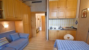 Una cucina compatta con mobili in legno, un piano cottura e un lavello.