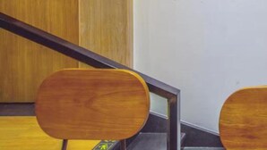 Une porte en bois avec une enseigne, un élément de décoration murale circulaire et une chaise en bois.