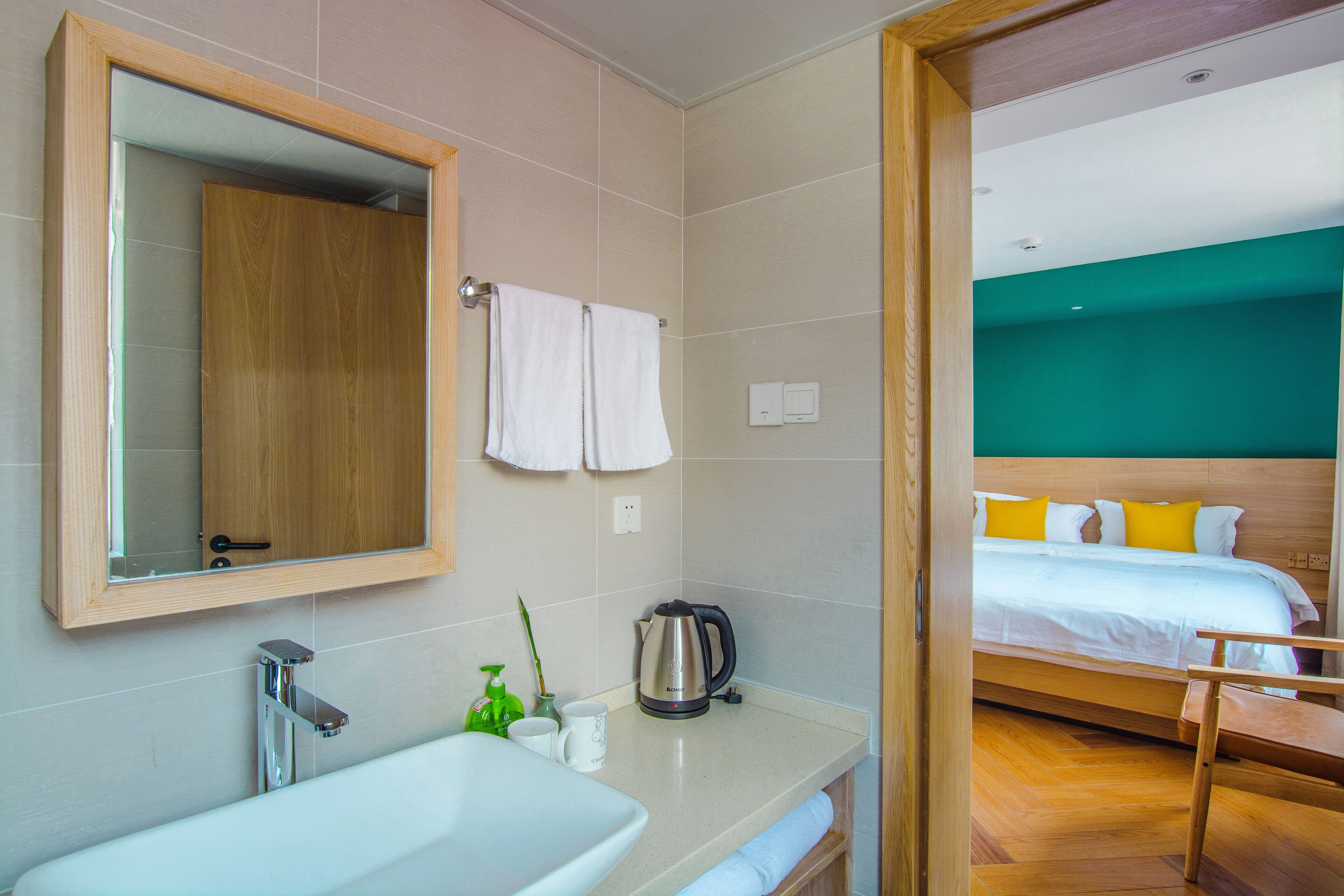 A modern bathroom with a large sink, mirror, and a wooden cabinet.