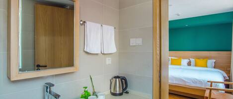 A modern bathroom with a large sink, mirror, and a wooden cabinet.