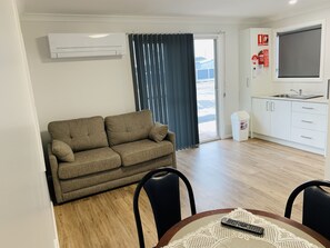 Cabaña Deluxe | Área de sala de estar | Televisión de pantalla plana de 20 pulgadas con canales digitales 