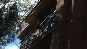 A building with a brick facade and a metal balcony railing.