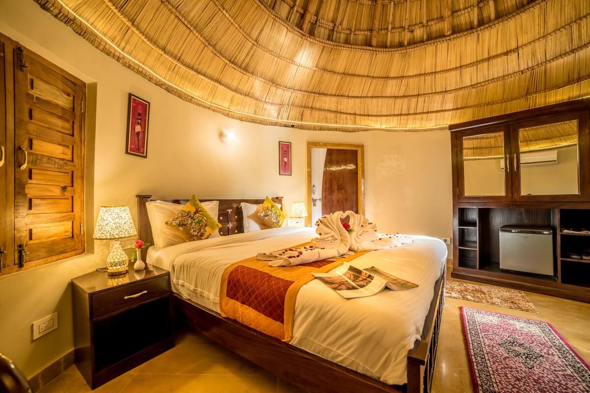 Een hotelkamer met een bed, nachtkastje en een spiegel.
