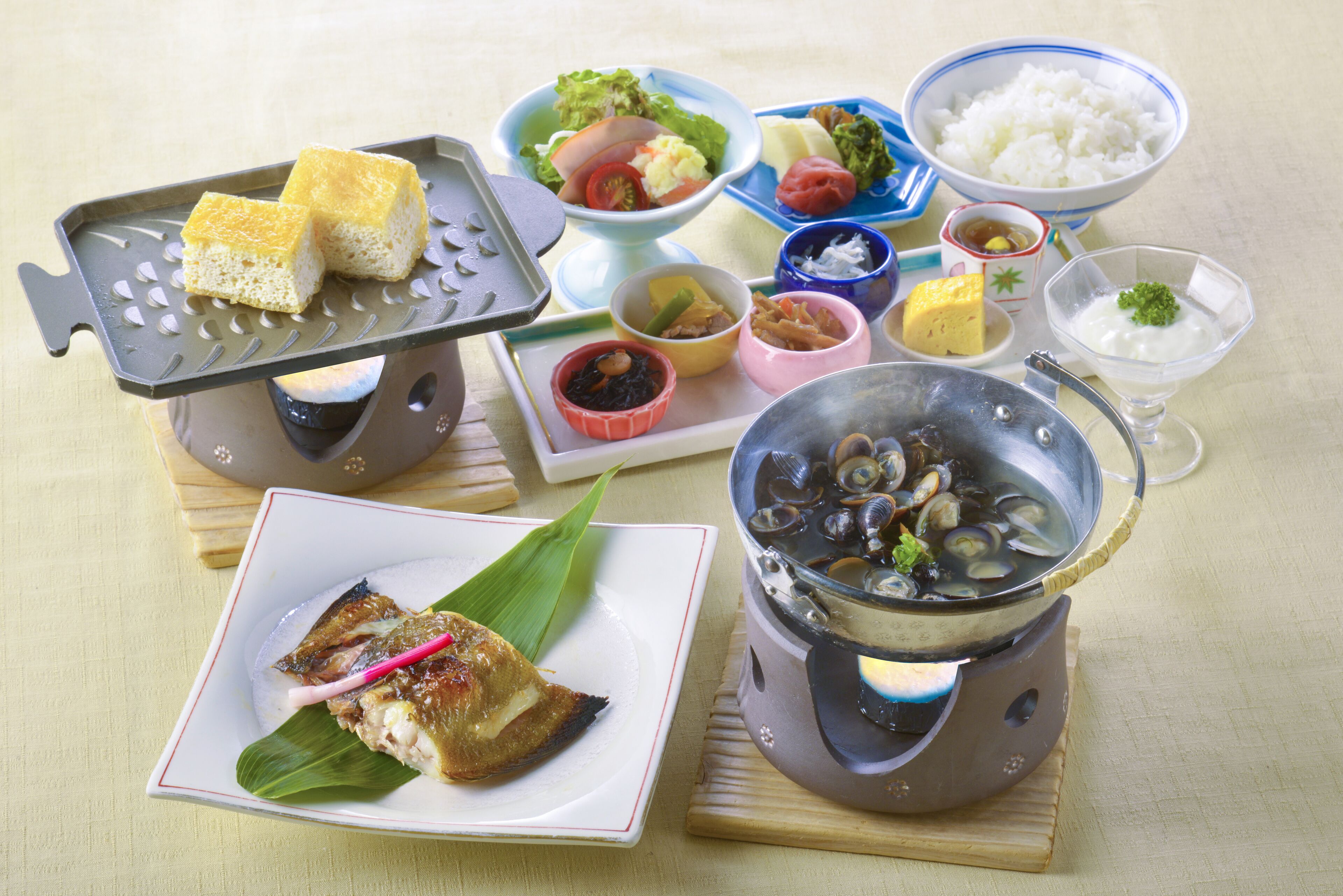 A variety of dishes including seafood, rice, and vegetables, served on a wooden table.