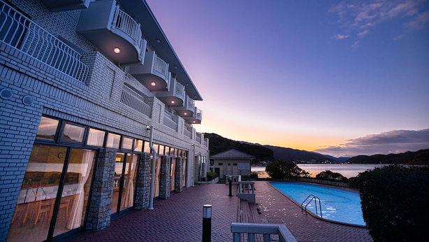 Un hotel con piscina, zona de estar al aire libre y vista al agua.