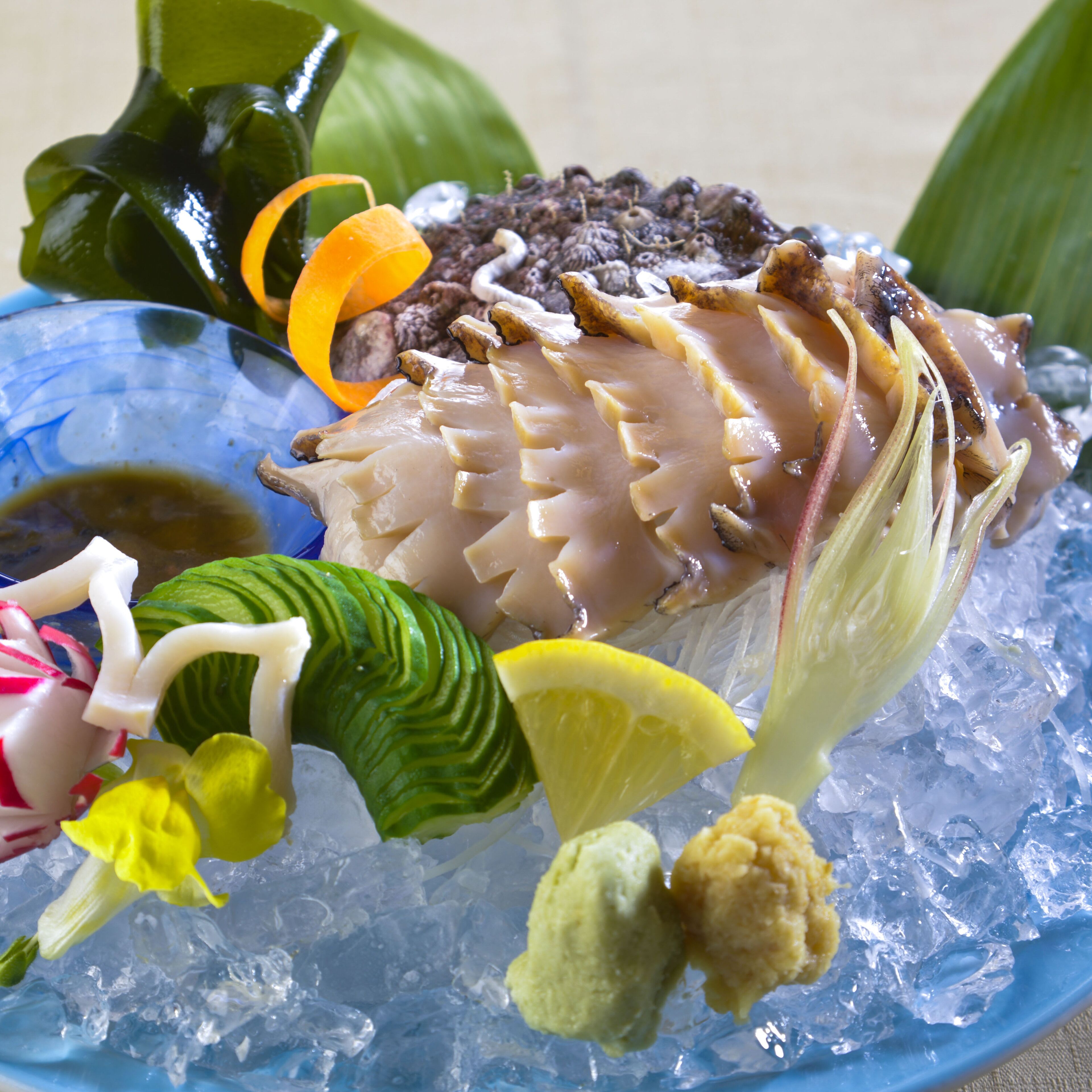 A seafood dish with ice and garnishes on a blue plate.