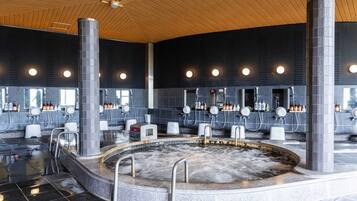 Een wellnessruimte met een jacuzzi, meerdere wastafels en een houten plafond.