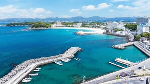 Un paisaje urbano costero con un puerto deportivo, edificios y cielo despejado.