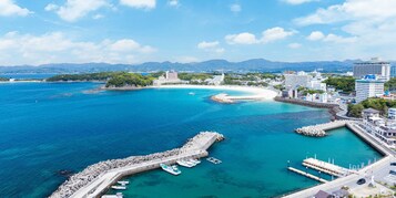 Un paisaje urbano costero con un puerto deportivo, edificios y cielo despejado.