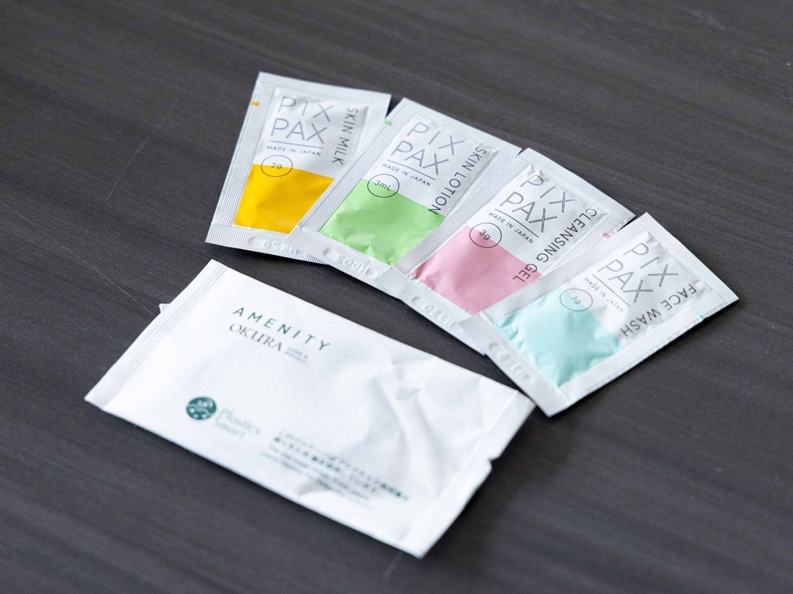 A collection of Pix PAX skincare products, including face wash and cleansing gel, on a dark surface.