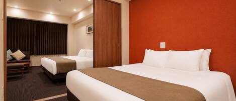 A hotel room with a large bed, a sofa, and a desk.