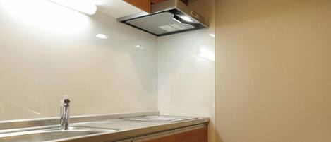 A modern kitchen with wooden cabinets, a stainless steel sink, and under-cabinet lighting.