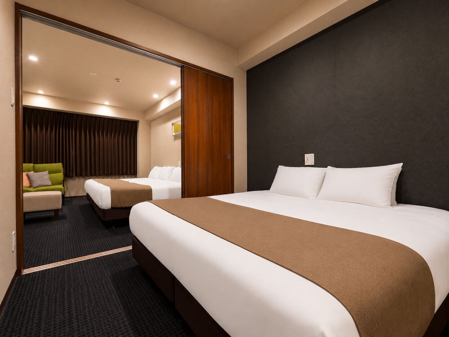 Une chambre d’hôtel avec un grand lit, un canapé, un bureau et un rideau.