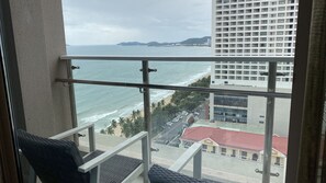Un balcon avec vue sur l’océan et sur le paysage urbain.