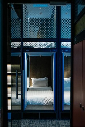 Una habitación con una cama, una puerta y una ventana.