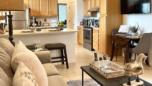 Un salon moderne avec un canapé, une table basse et un téléviseur.