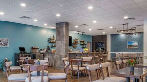 A restaurant with a bar area, seating arrangements, and a view of the sea. - The Cranberry, an Ascend Collection Hotel (Morgantown)