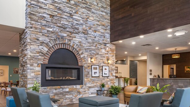 A lobby with a stone fireplace, seating area, and a reception desk. - The Cranberry, an Ascend Collection Hotel (Morgantown)