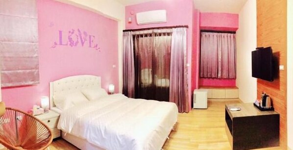 A bedroom with a bed, a chair, a TV, and a small table. - Happy Wind Homestay (Magong)