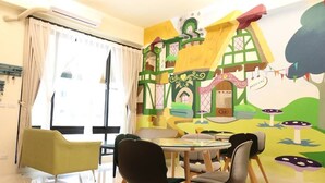 Un comedor con una mesa y sillas, un mural en la pared y un ventilador de techo.