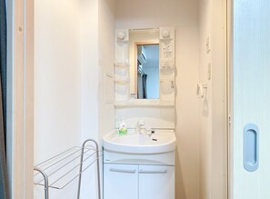 A small bathroom with a white sink, a mirror, and a towel rack.