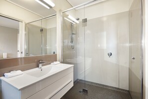 Appartement | Badkamer | Een douche, een haardroger, handdoeken, zeep