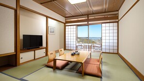 A traditional Japanese-style room with tatami flooring, a low wooden table, and a television on a cabinet. - The Grand Resort Princess Arima (Kobe)