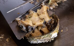 A close-up of a cooked oyster with a spatula. - The Grand Resort Princess Arima (Kobe)