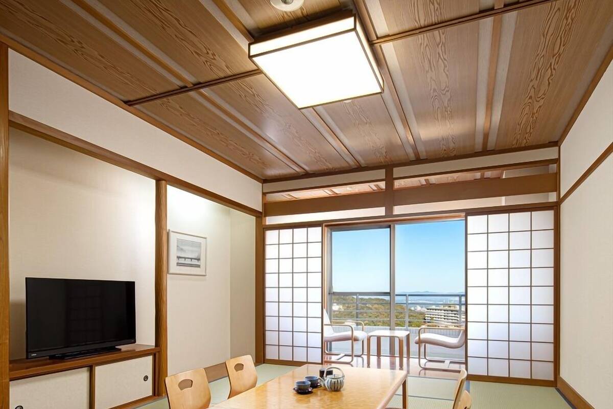 A traditional Japanese-style room with tatami flooring, a low table, and sliding shoji doors.