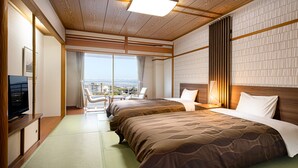 A hotel room with two beds, a television, and a view of the city. - The Grand Resort Princess Arima (Kobe)