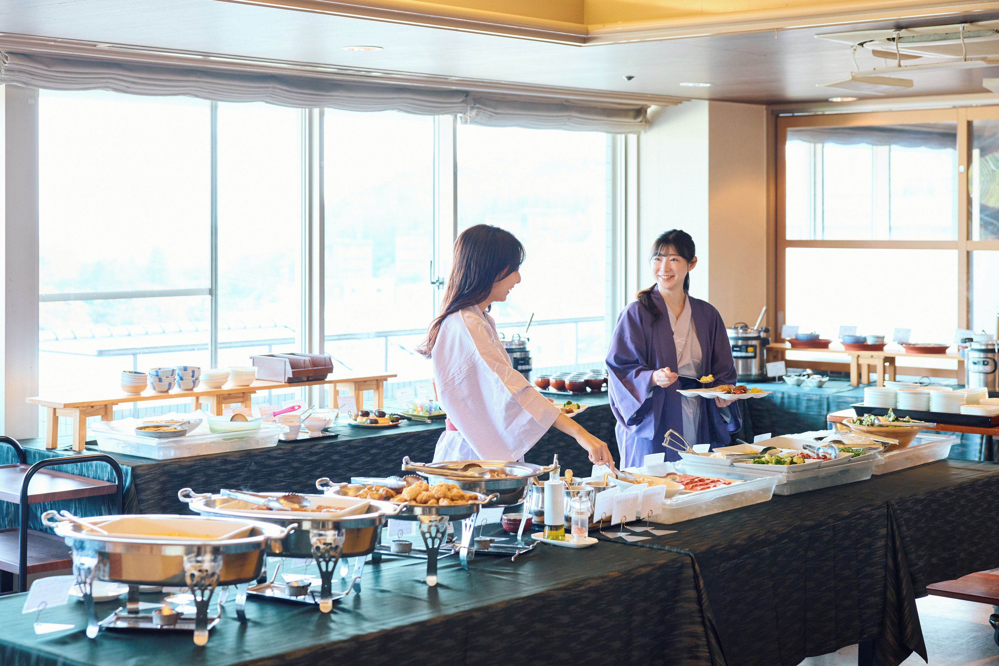 A buffet setup with various food items and serving utensils.