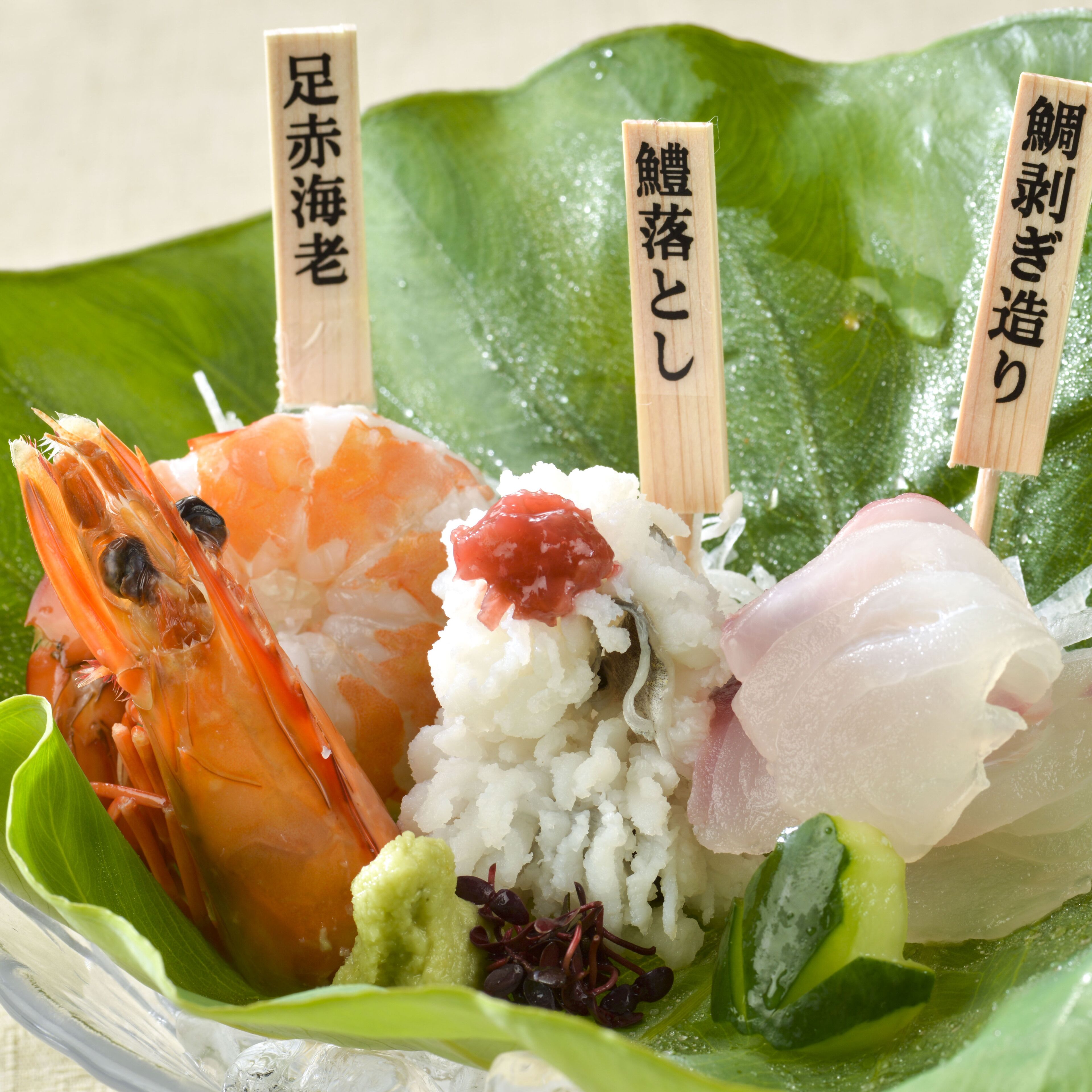 Une assiette de sushis, garnis de divers ingrédients, et une feuille verte en dessous.