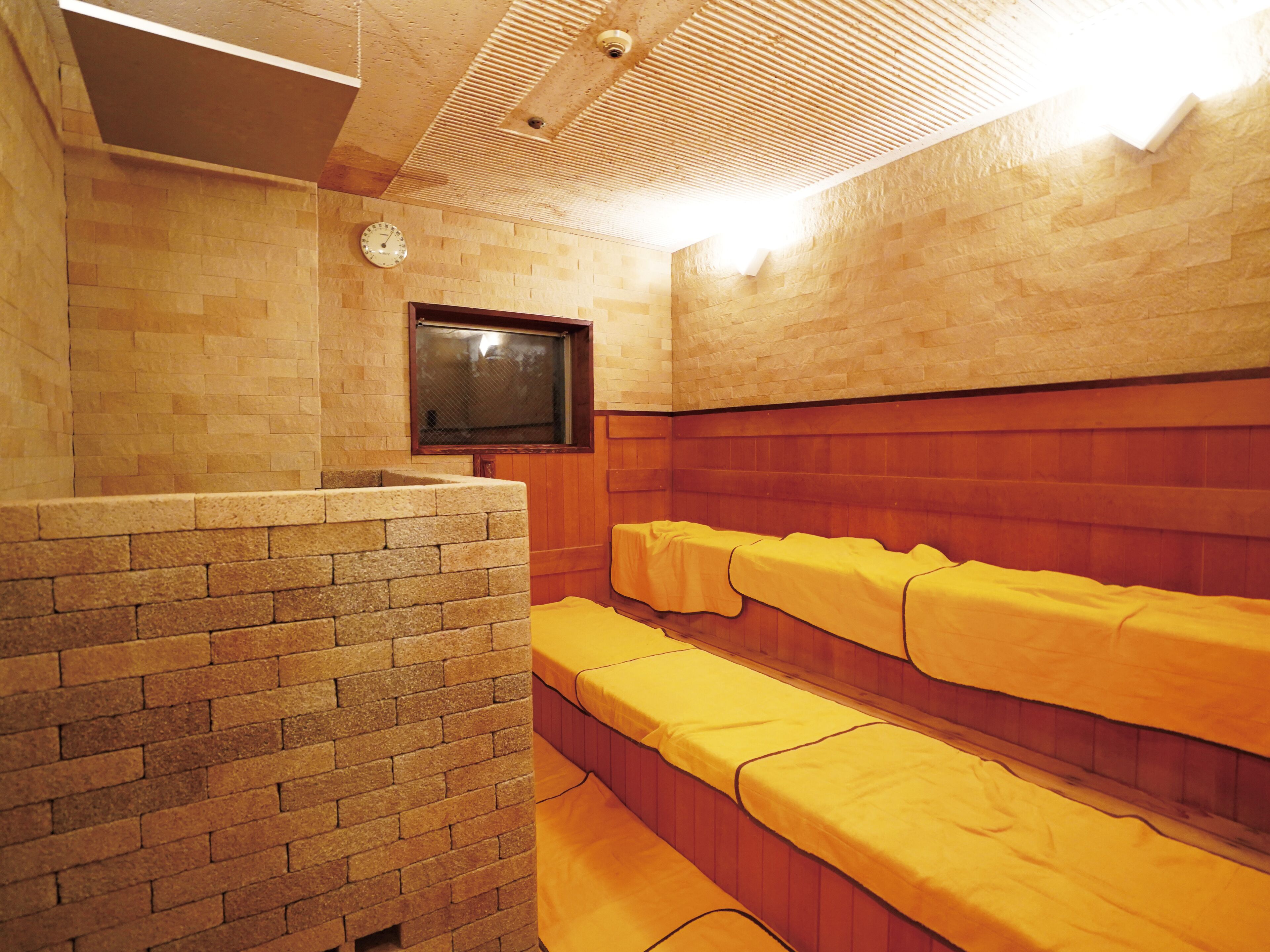 A sauna room with wooden benches and a clock on the wall.
