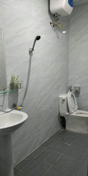 A bathroom with a sink, toilet, and shower. - Hoang Anh Guest House (Hai Phong)