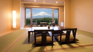 A dining area with tatami mats, a table, chairs, and a view of Mount Fuji. - The Gran Resort Princess Fujikawaguchiko (Fujikawaguchiko)