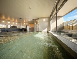 Une grande piscine intérieure dotée de plusieurs couloirs, d’un espace vestiaire et d’un sauna.