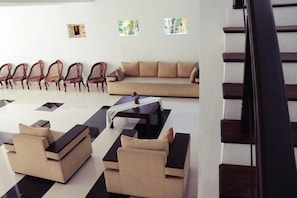 Un salon moderne avec un canapé, des fauteuils et une table basse.