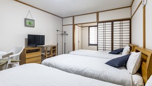 A room with two beds, a desk with a TV, a chair, and a window with a view. - Tabist Beppu kitahama no yado ao (Beppu)