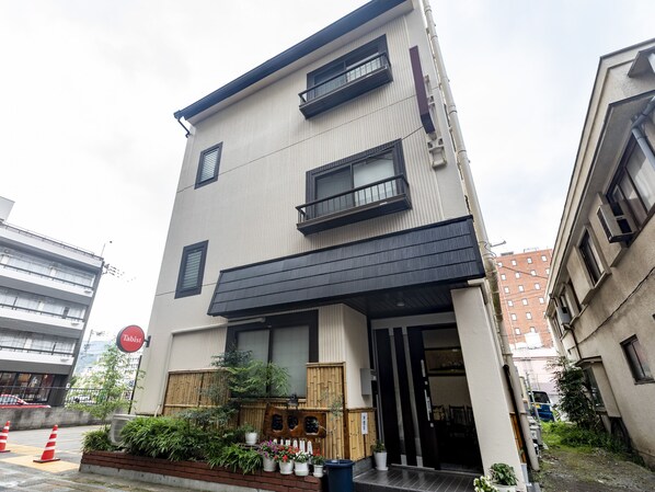 A modern building with a flat roof, multiple balconies, and a wooden gate at the entrance. - Tabist Beppu kitahama no yado ao (Beppu)