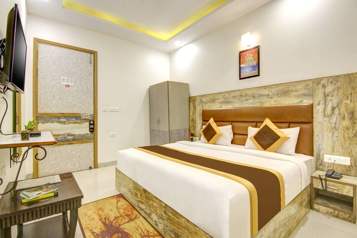 Une chambre d’hôtel avec un grand lit, une télévision, un bureau et une armoire.