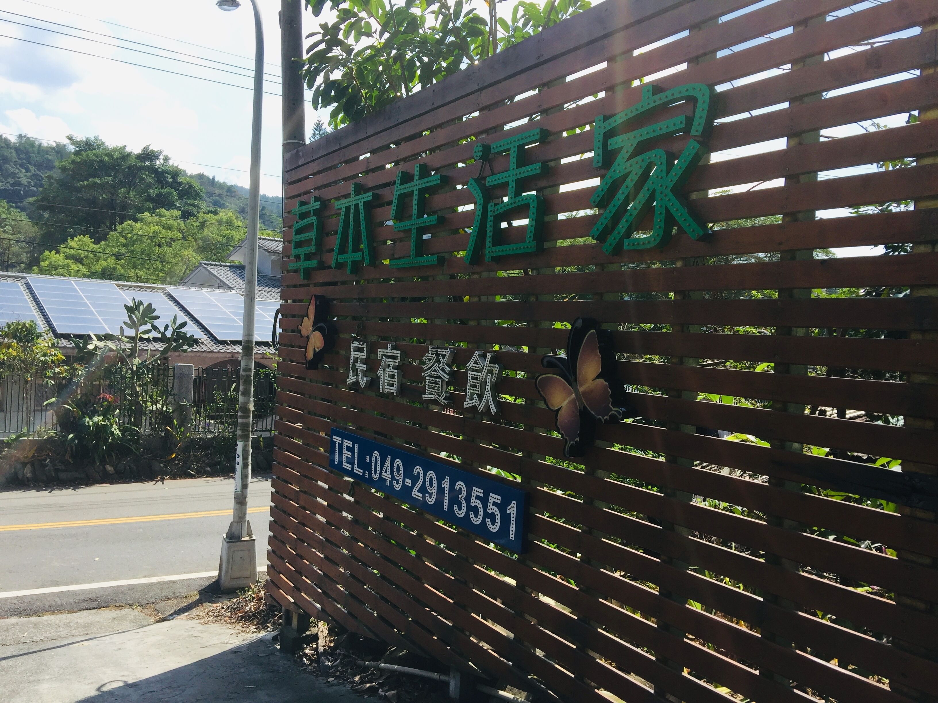 A wooden fence with a sign that reads "Chengdu Life Home" and a telephone number.