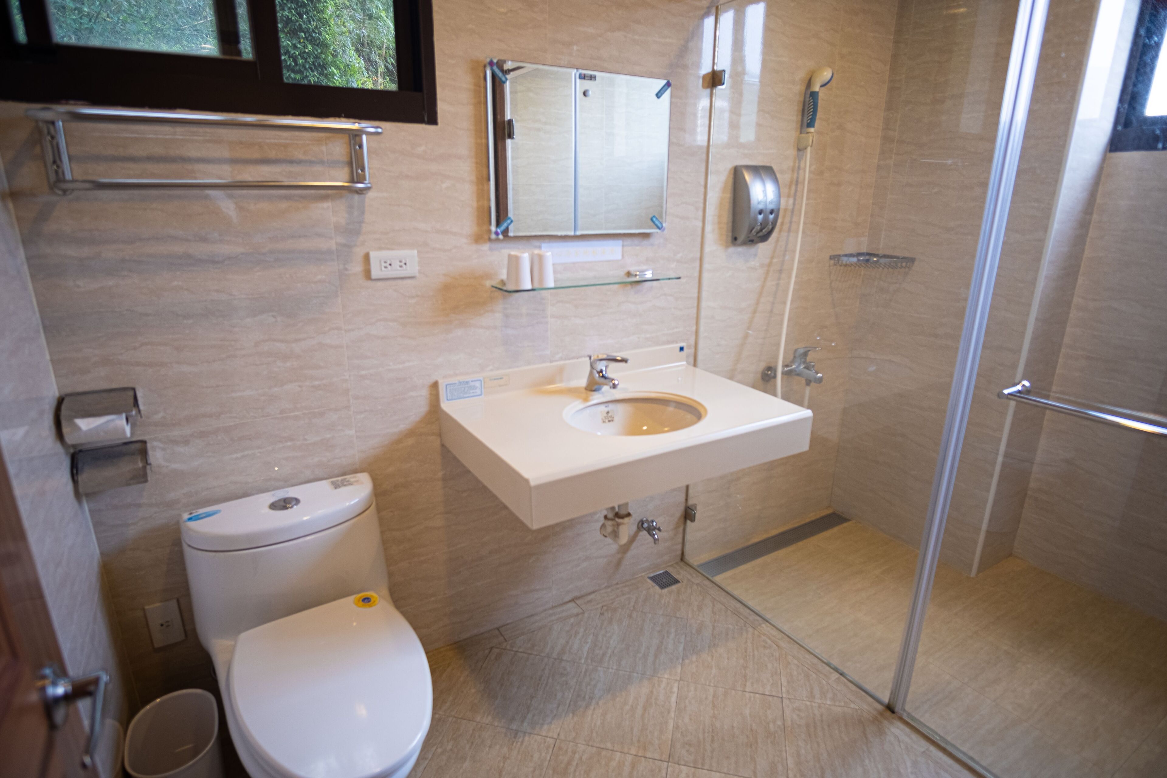 Un baño moderno con inodoro, lavabo y cabina de ducha de vidrio.