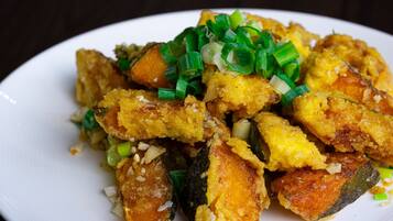 A plate of fried food with green onions on top.